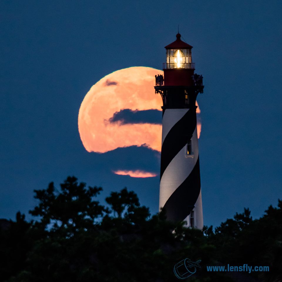 beautiful photograph of lighthouse against cloud covered moon