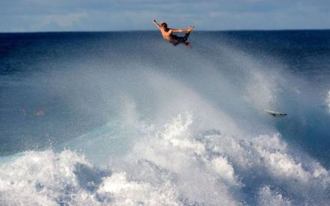 surfer launches from huge wave