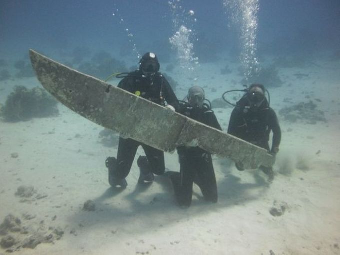 scuba divers find giant knife underwater and pose with it