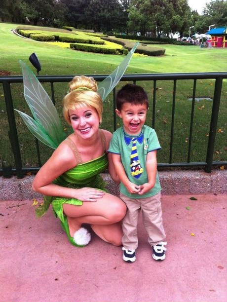 kid poses with cute tinker bell at disney world