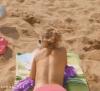topless girl throws ball back on beach