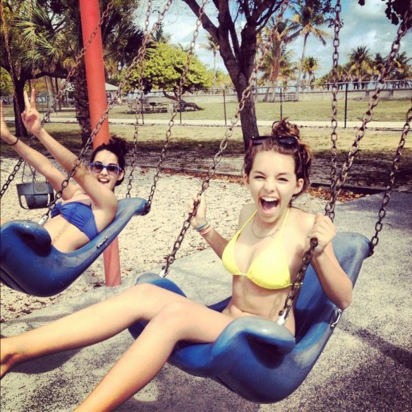 girls in bathing suits go for a swing