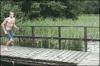 guy tries to jump off dock but slips and flips himself over the railing, lol, fail, gif