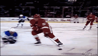 hockey player comes out of nowhere and hits boards near camera