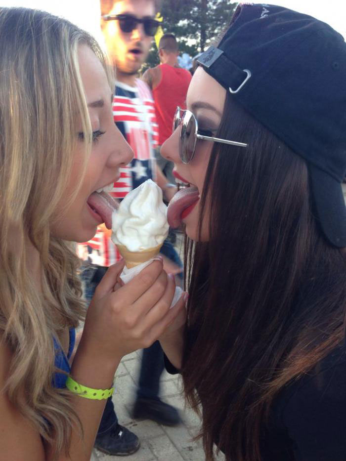 two girls licking ice cream, guy reacts behind them