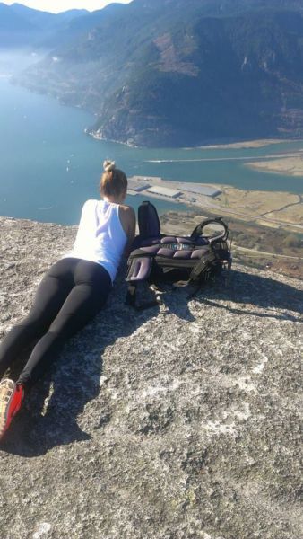 oh my god look at those buildings they must be huge, girl lying down with view of water and land off cliff