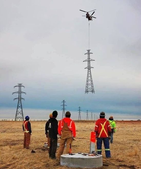 helicopter bringing a power line to the site, construction machines