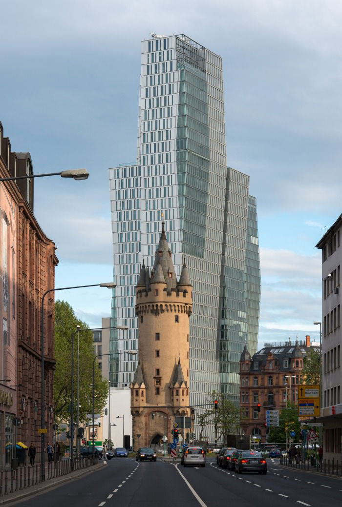 600 year old tower in front of a modern high rise in frankfurt