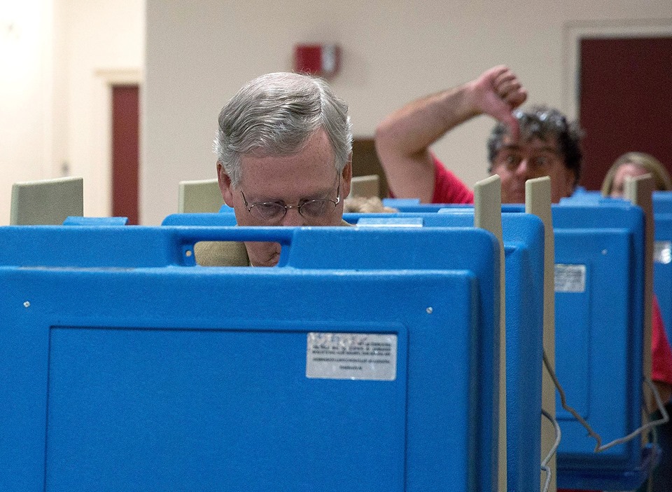 mitch mcconnell photobombed with a thumbs down at the polls
