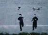 the latest banksy piece, kid flying a kite, kid running from a drone