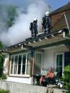 man smoking cigarette on porch of burning house