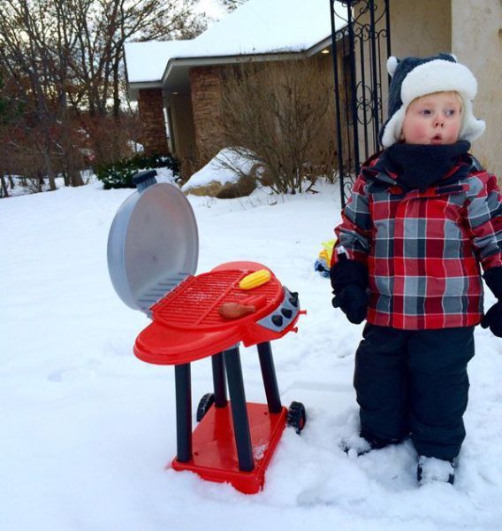 snowbq!, kid using toy barbecue to pretend bbq in the yard during the winter