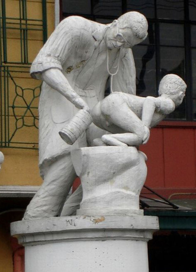 statue of a man holding a can behind a kid's ass, wtf