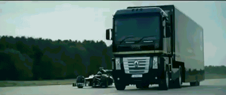 f1 car driving under a semi truck off a jump