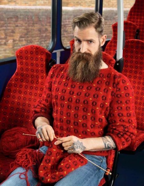 a man with a long beard knitting a sweater that looks like bus seats