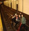 four girls posing on subway tracks, stupid