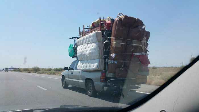 you only ever need one trip, overloaded pick up truck with furniture and belongings