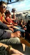 guy in stadium using his baseball cap to block the sun