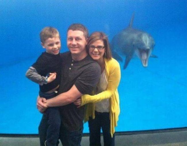 happy dolphin photobombs family at aquarium