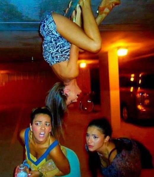 this picture makes no sense, girl hanging from ceiling with two others looking scared or confused or sad