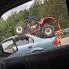 car transporting a four wheeler on it's roof