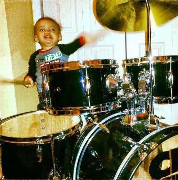 toddler drummer going crazy on his drum set, cute