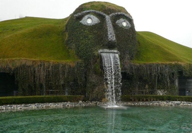 river coming out of a mouth carved into a hill