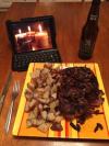 a romantic dinner for one, candles burning on a laptop screen, stone ripa, steak and fried potatoes