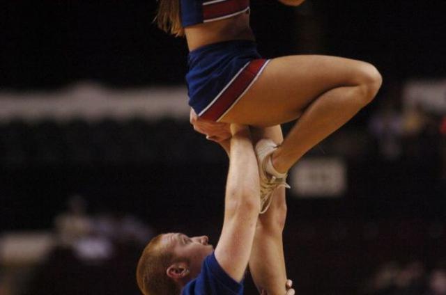 the one straight cheerleader guy helping out as best he can, hand supporting girl's crotch