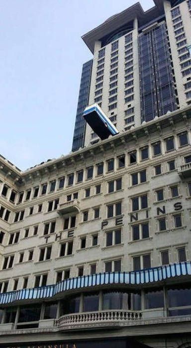 just a bus dangling dangerously over the edge of a building's roof
