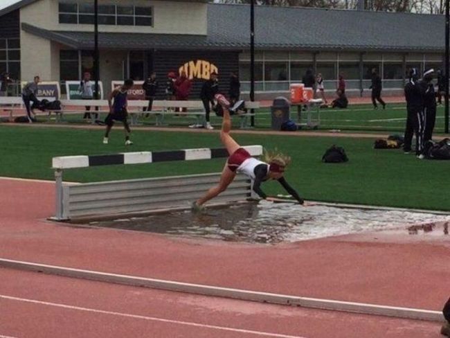 perfectly timed photo of girl wiping out over hurdle into water