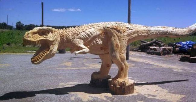 epic carving of a dinosaur out of a tree