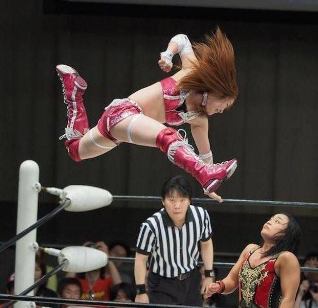 female wrestler in mid air delivering acrobatic punch