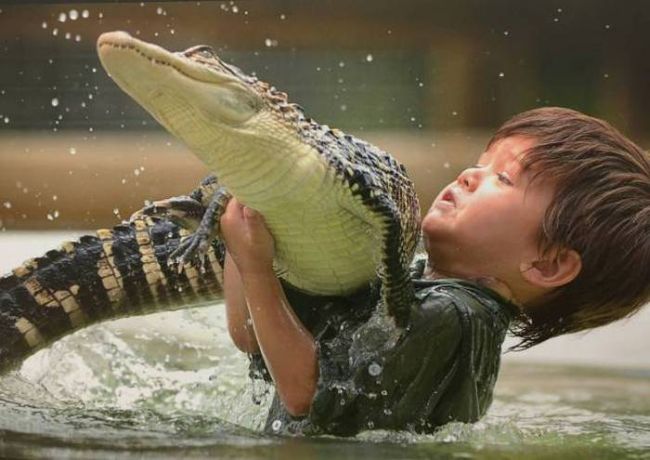 kid wrestling small crocodile 