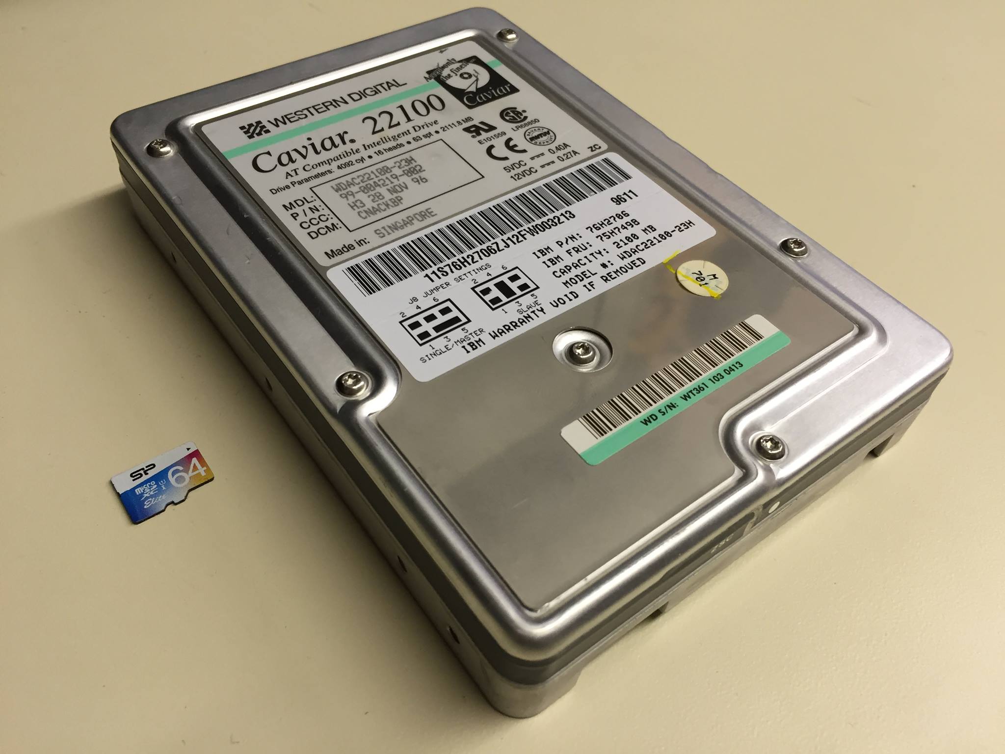 a 2gb hard drive next to a 64gb microsdxc card