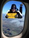 man skydiving outside plane window with sign that says i was your pilot