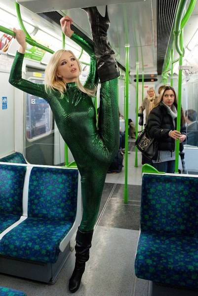 flexible in public transportation wearing a shiny green jumpsuit