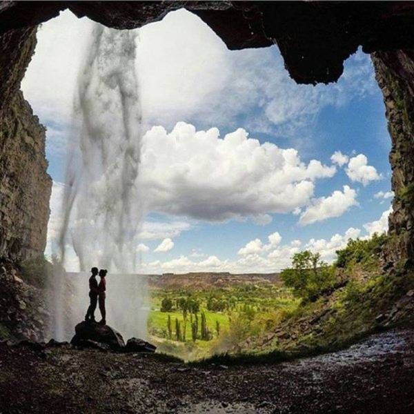 kissing in a cave mouth waterfall