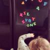 kil evry one, kid playing with fridge magnets