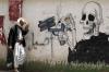 smoking kills, street art of skeleton loading gun with cigarettes