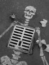 man hole skeleton, street art