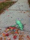 alien sweeping the leaves under the sidewalk, street art