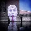 street art of lady drinking from straw in canal