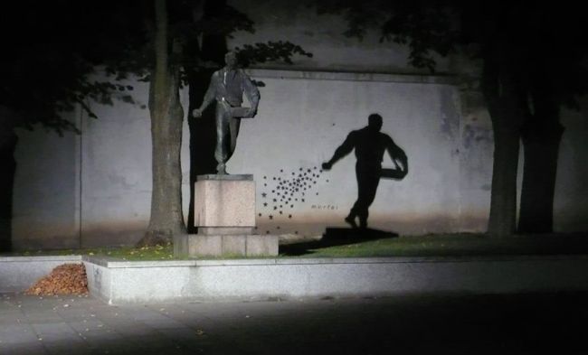 shadow of statue dropping leaves in the wind