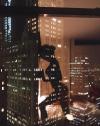 curvaceous female reflection in high rise window at night