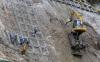 excavator on steep embankment, unsafe work conditions