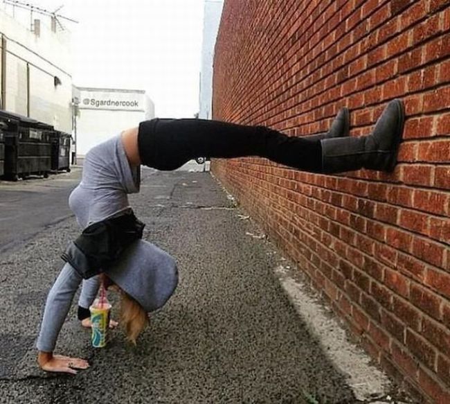 drinking soda while leaning against a wall