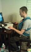 fatherhood for a millennial, baby in sling while gaming