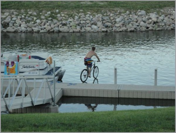 looks like jesus learned to ride a bike, bicycle on water, perfectly timed photograph