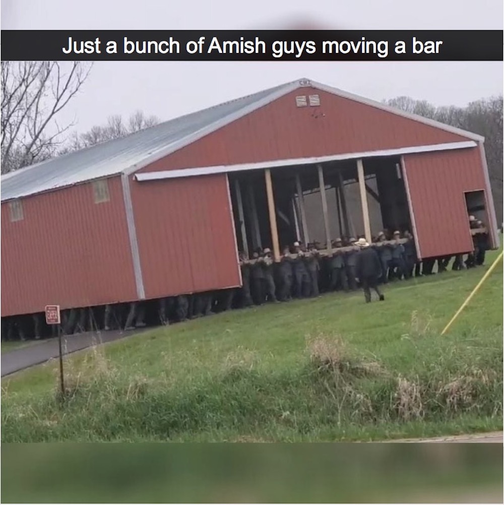 just a bunch of amish guys moving a barn, man power